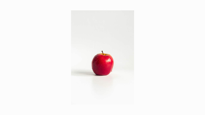 A whole apple with a leaf on its stem