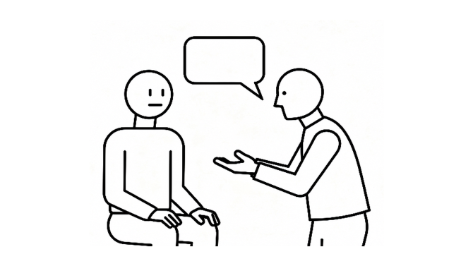 An adult giving calm feedback to a seated pupil