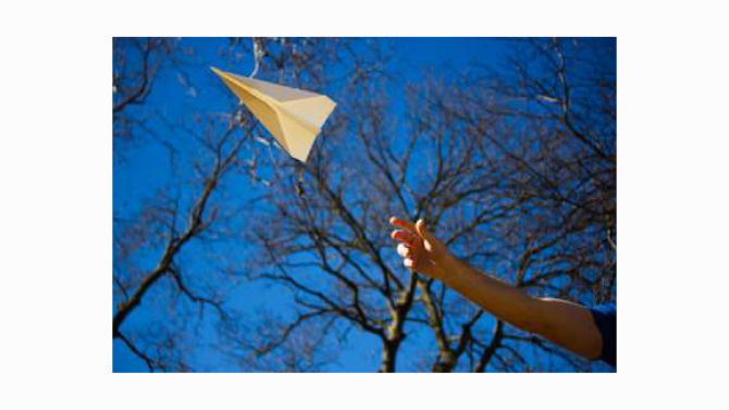 A paper airplane gliding upward