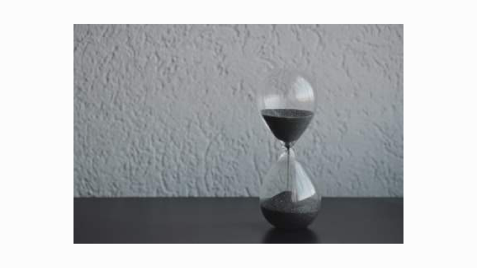 A sand timer with visible sand in the top bulb